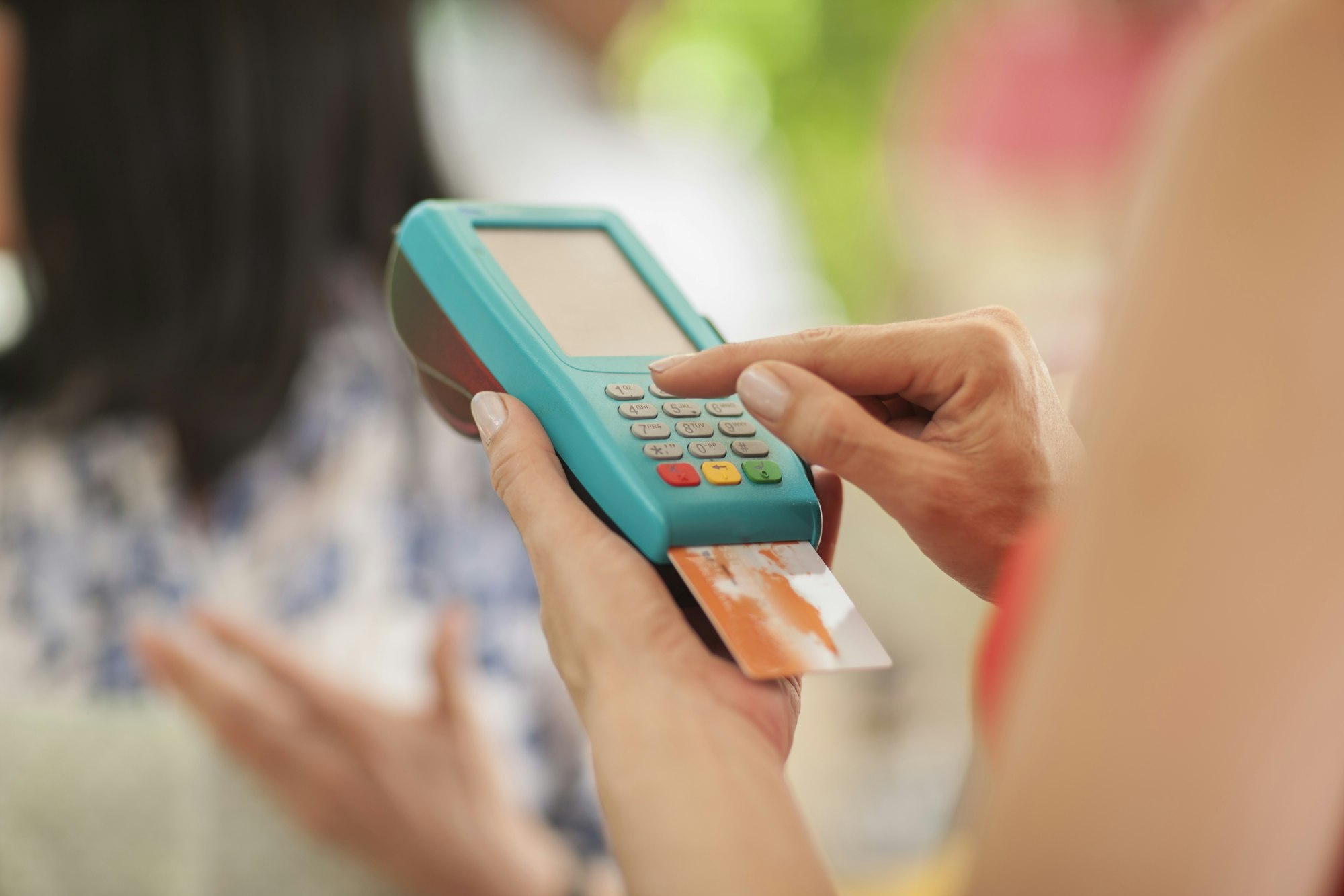 Tourist paying market trader with credit card