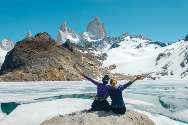 two friends have fun posing for a photo with Fitzroy Mountain in the background